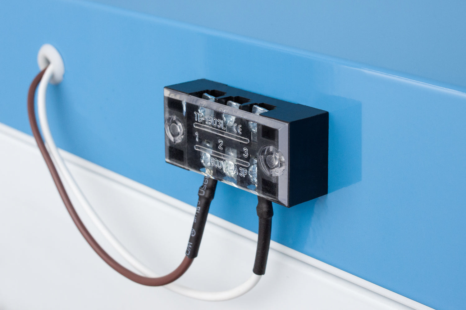 Close-up of electrical terminal block with connected wires mounted on blue and white laboratory refrigerator in Appliances collection