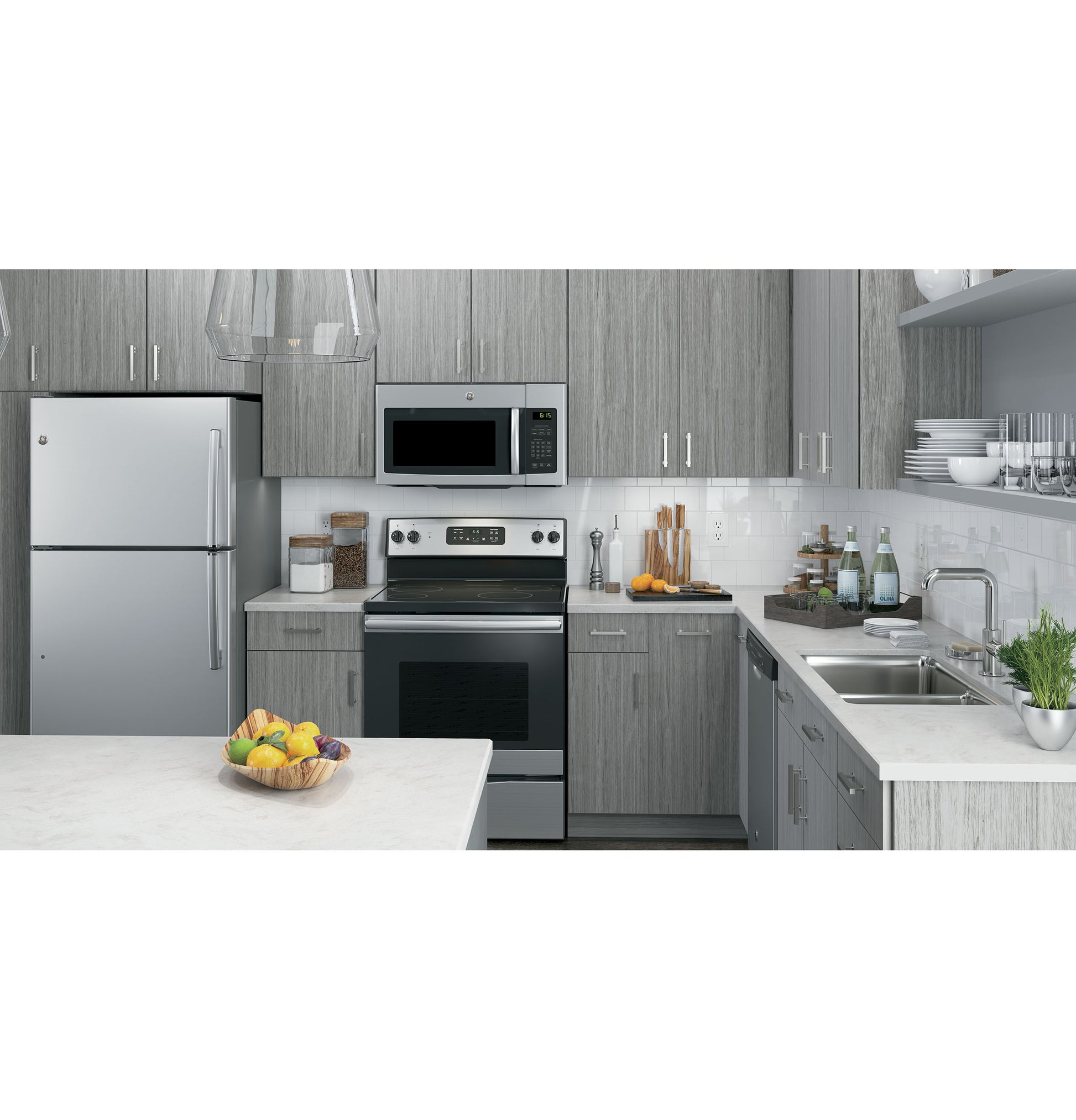 Modern kitchen with stainless steel over-the-range microwave and matching appliances in a grey wood cabinetry setting