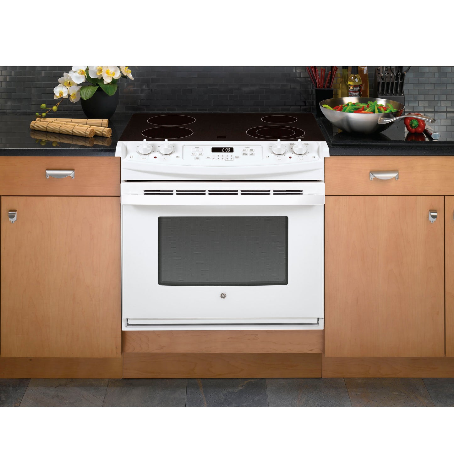 White drop-in electric range with smooth cooktop, control knobs, digital display, and oven window in kitchen appliances collection