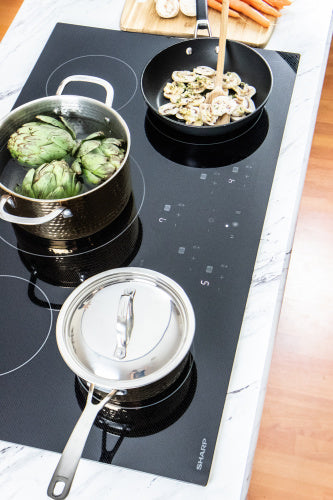 European black mirror induction cooktop with five cooking zones in a home kitchen setting for cookware use