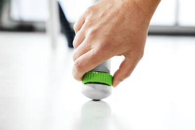 Close-up of hand adjusting green and gray leveling foot on woodworking tool underframe for stability and mobility solutions