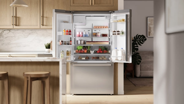 Spacious stainless steel French door refrigerator with bottom freezer open to reveal organized fresh produce and beverages inside
