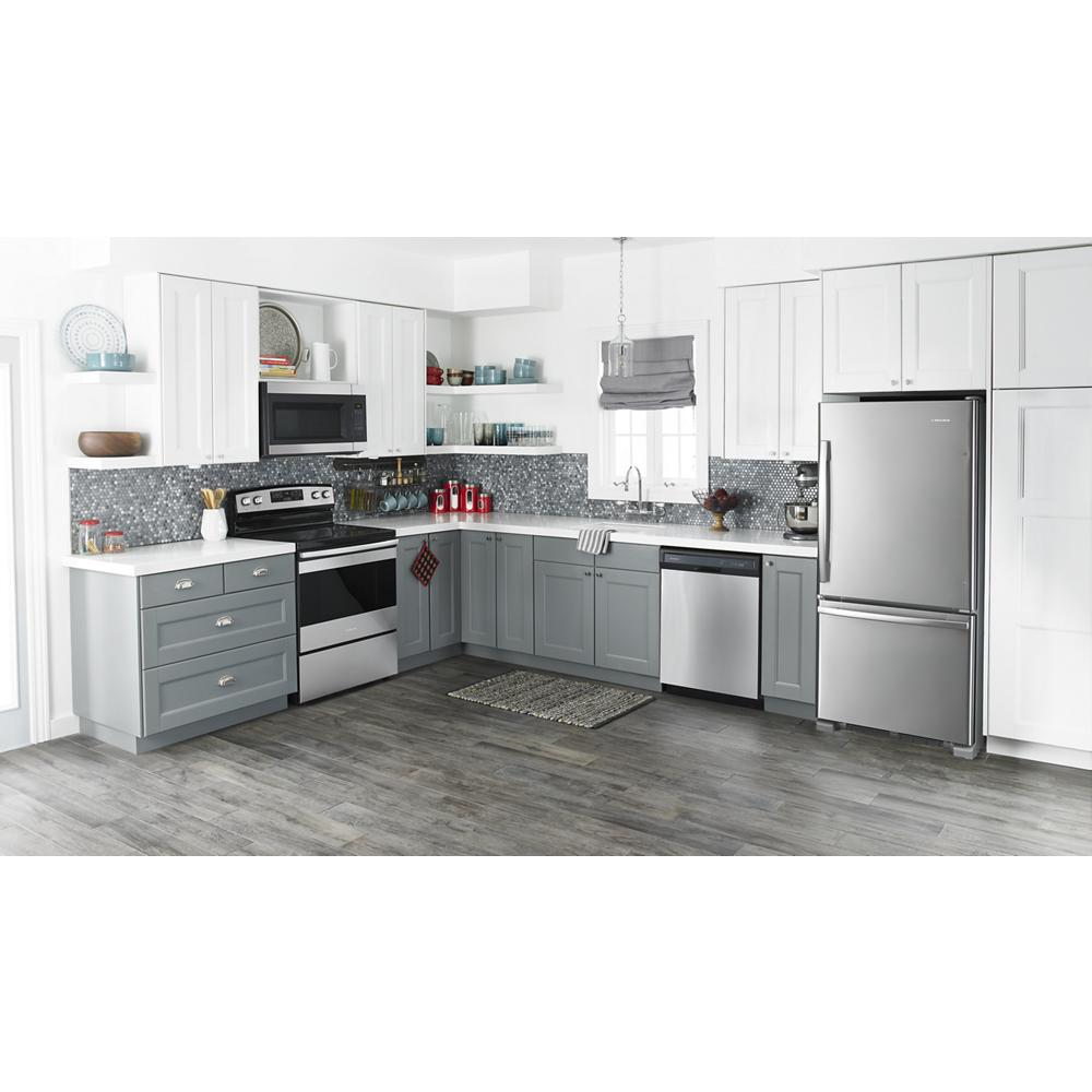Modern kitchen with stainless steel bottom-freezer refrigerator, gray cabinets, and matching appliances in bright setting