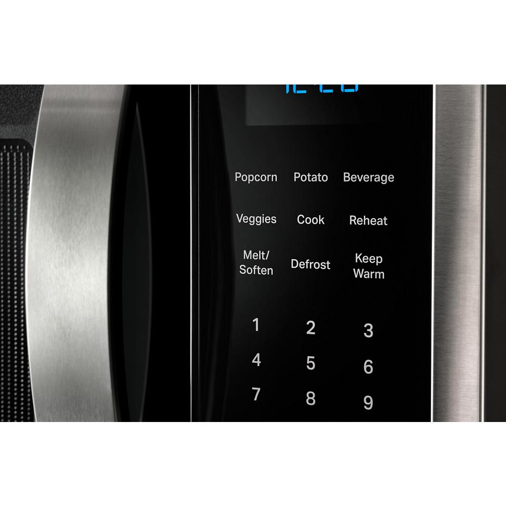 Close-up of stainless steel microwave control panel with sensor cooking settings and numeric keypad in kitchen appliances collection