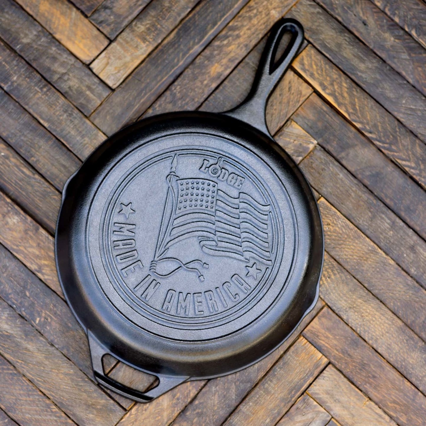 Overhead view of black cast iron skillet with embossed American flag and Made in America text on wooden surface