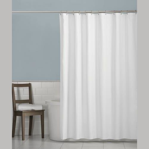 White fabric shower curtain liner hanging from silver rod in bathroom with blue wall and wooden chair