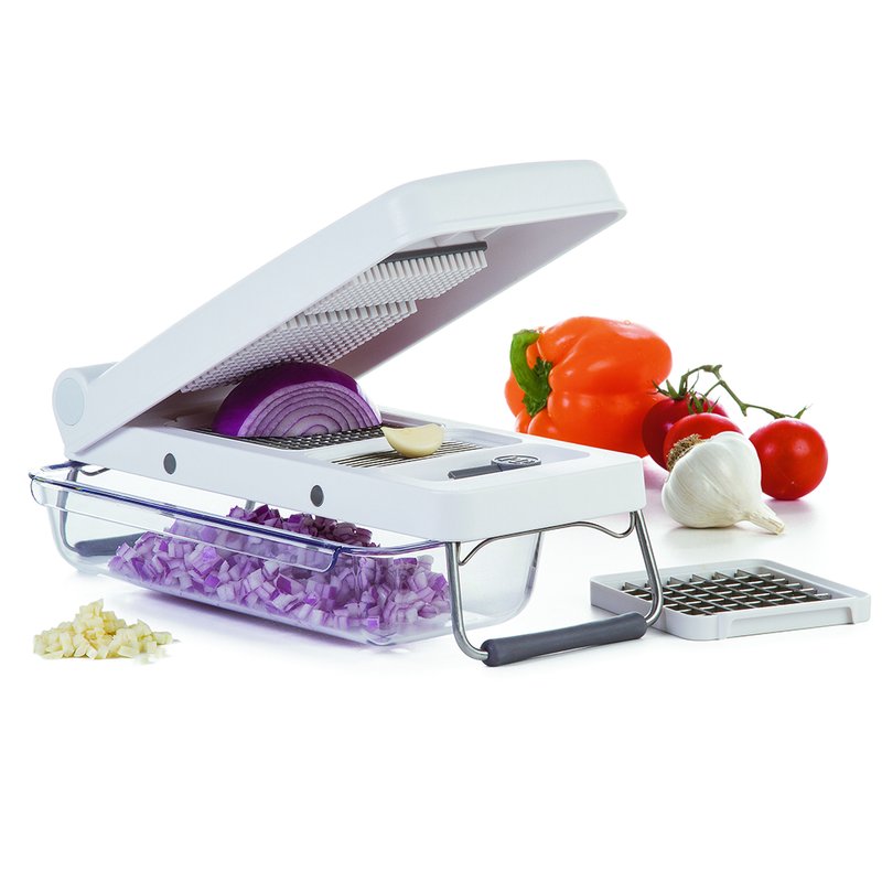 White durable professional chopper with glass container and interchangeable blades alongside fresh vegetables in kitchenware setting