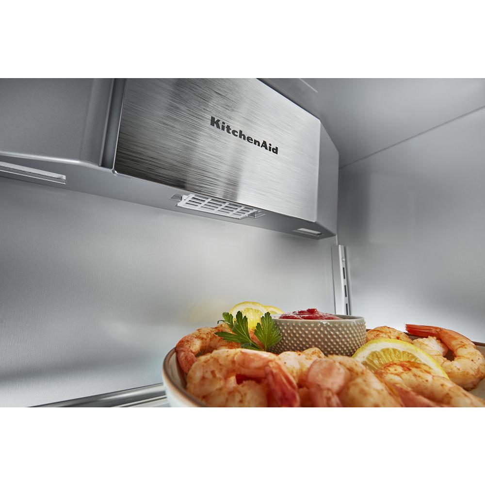 Interior view of built-in side-by-side refrigerator with stainless steel ice maker and shrimp appetizer plate inside