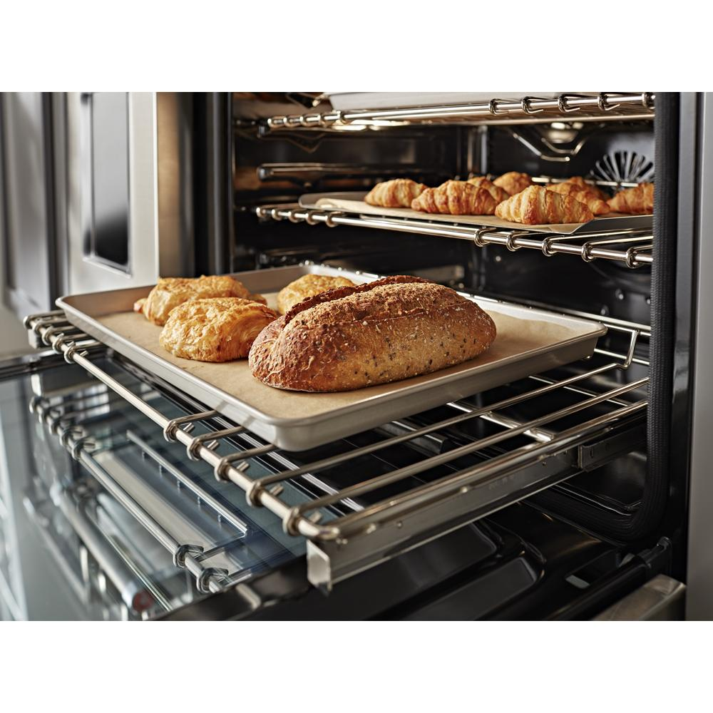 Inside view of oven with baked bread and croissants on metal racks in modern kitchen appliance setting