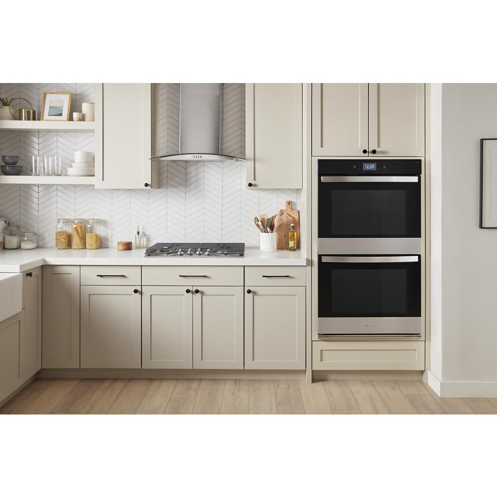 Modern kitchen with double smart wall oven installed in white cabinetry, featuring stainless steel and black accents in home appliances collection
