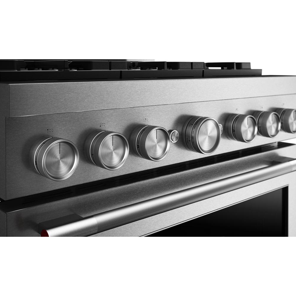 Close-up of stainless steel stove control panel with six round knobs on KitchenAid® commercial-style gas range.