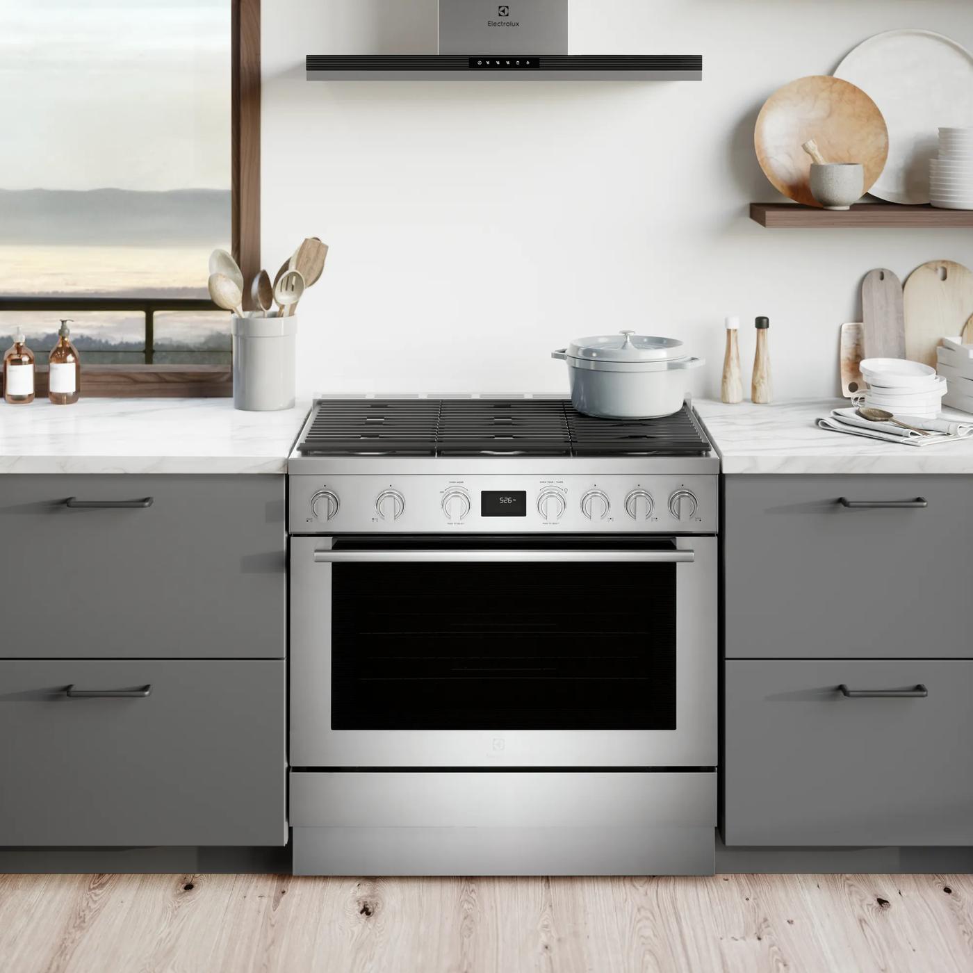 Modern stainless steel dual-fuel freestanding range with digital controls, gas cooktop, electric oven in kitchen appliance collection