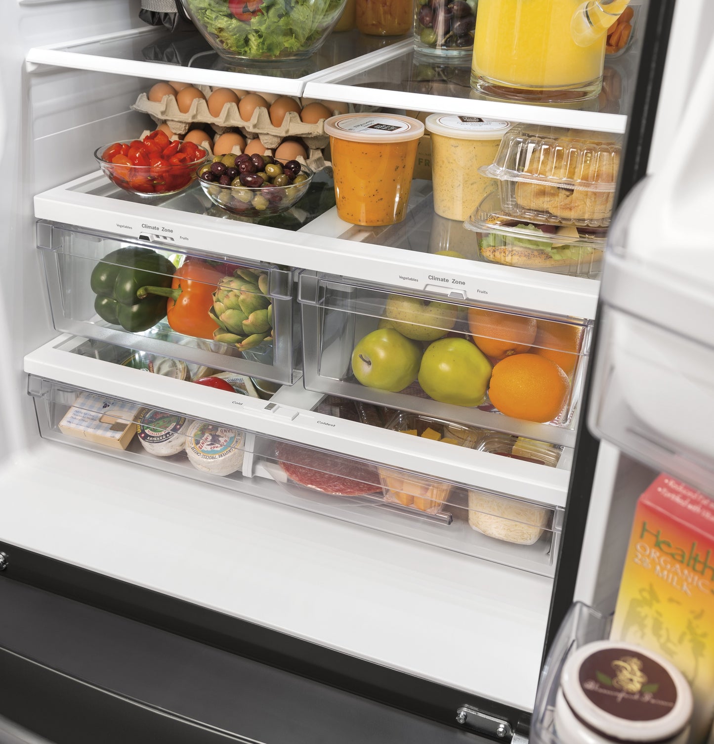 Open refrigerator with organized fresh produce, deli items, and beverages in clear drawers in French Door Refrigerators collection