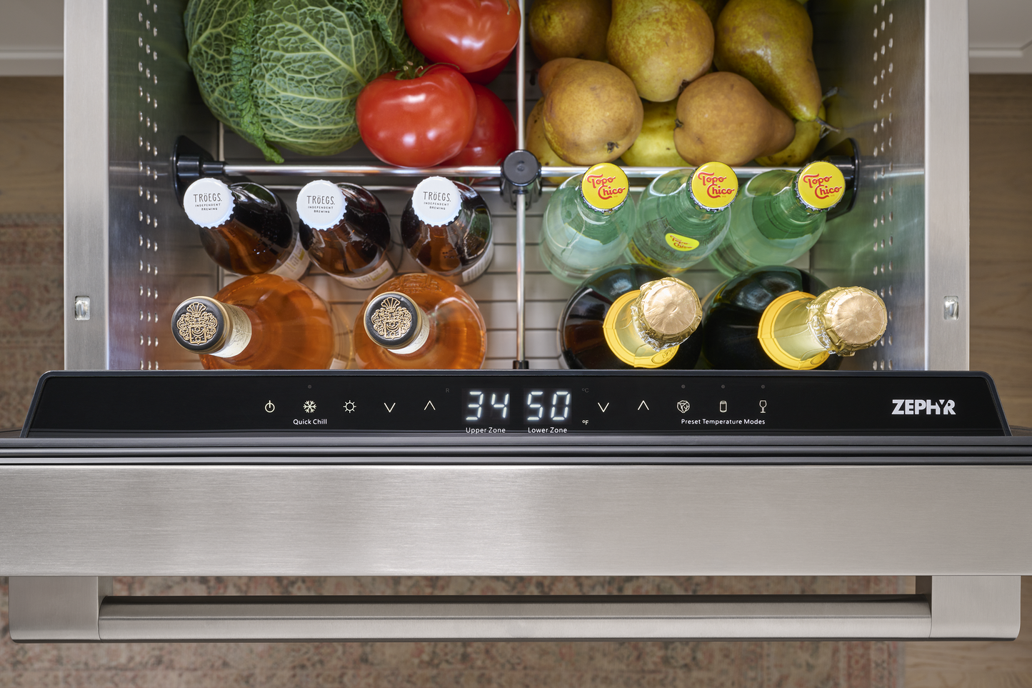 Stainless steel under-counter refrigerator drawer with dual zones, stocked with fruits, beverages, and vegetables in kitchenware collection
