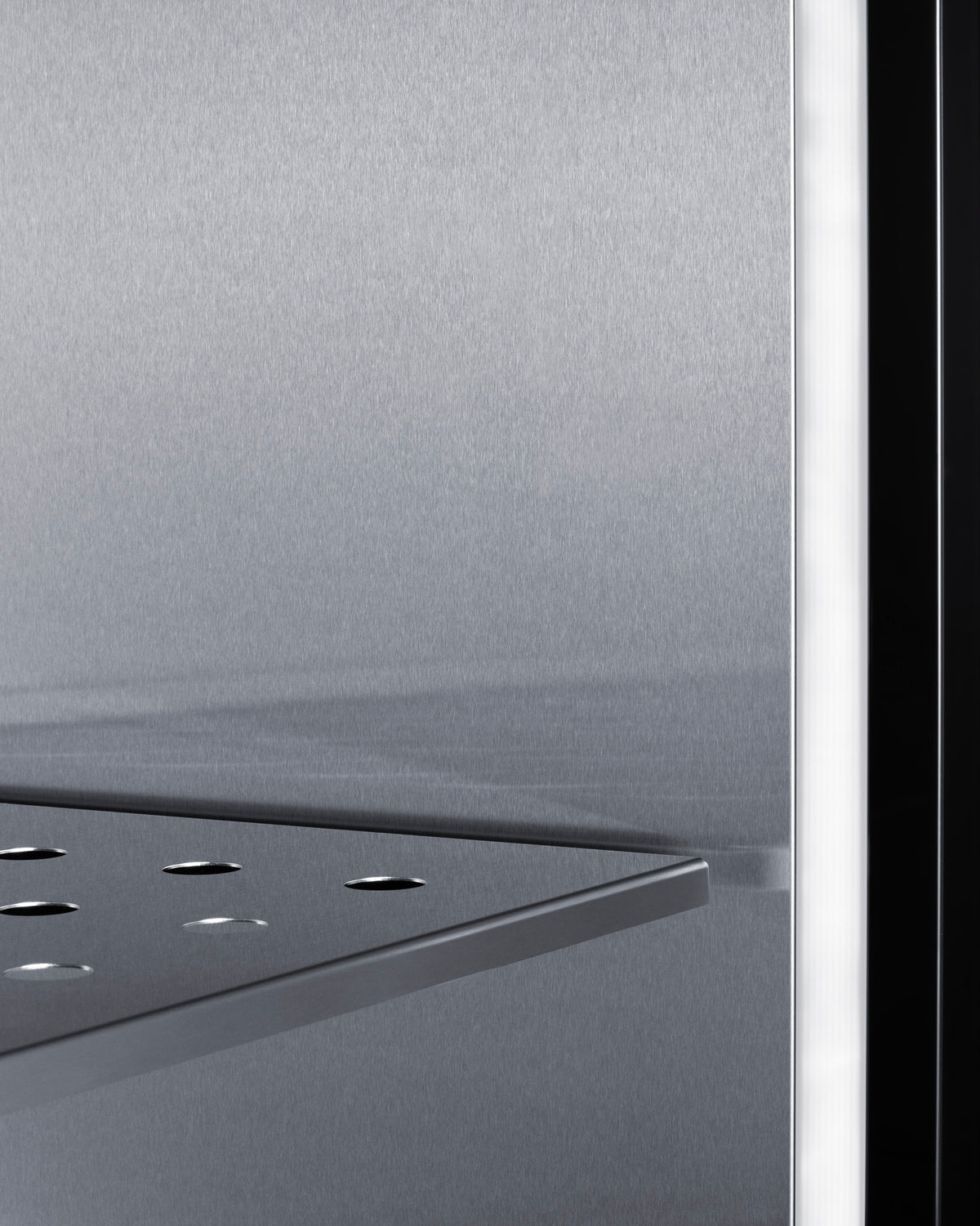 Close-up of stainless steel interior shelf and wall inside commercial undercounter freezer for kitchen use