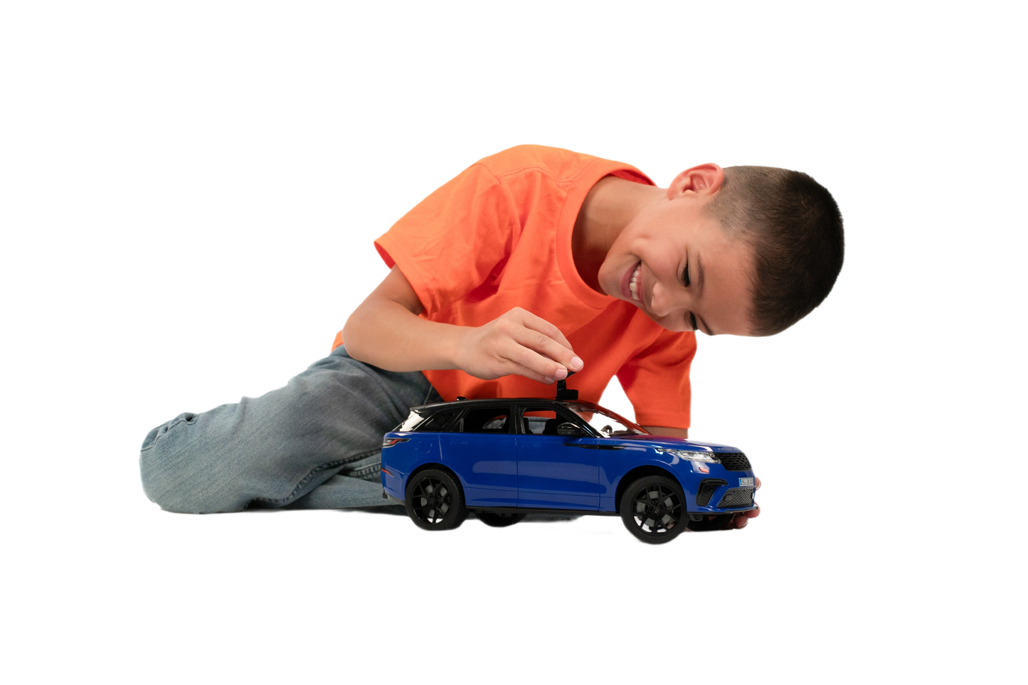 Young boy playing with detailed blue Bruder Range Rover Velar toy car indoors for imaginative play and display purposes