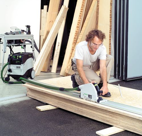 Man using Festool plunge saw with guide rail on plywood outside workshop, part of power tools and home improvement collection