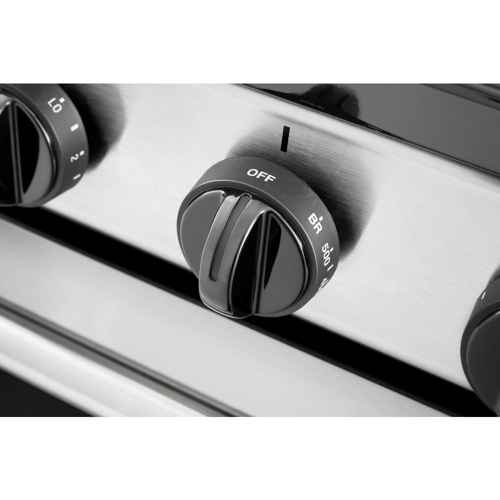 Close-up of black control knob on stainless steel electric range for kitchen and home improvement collections
