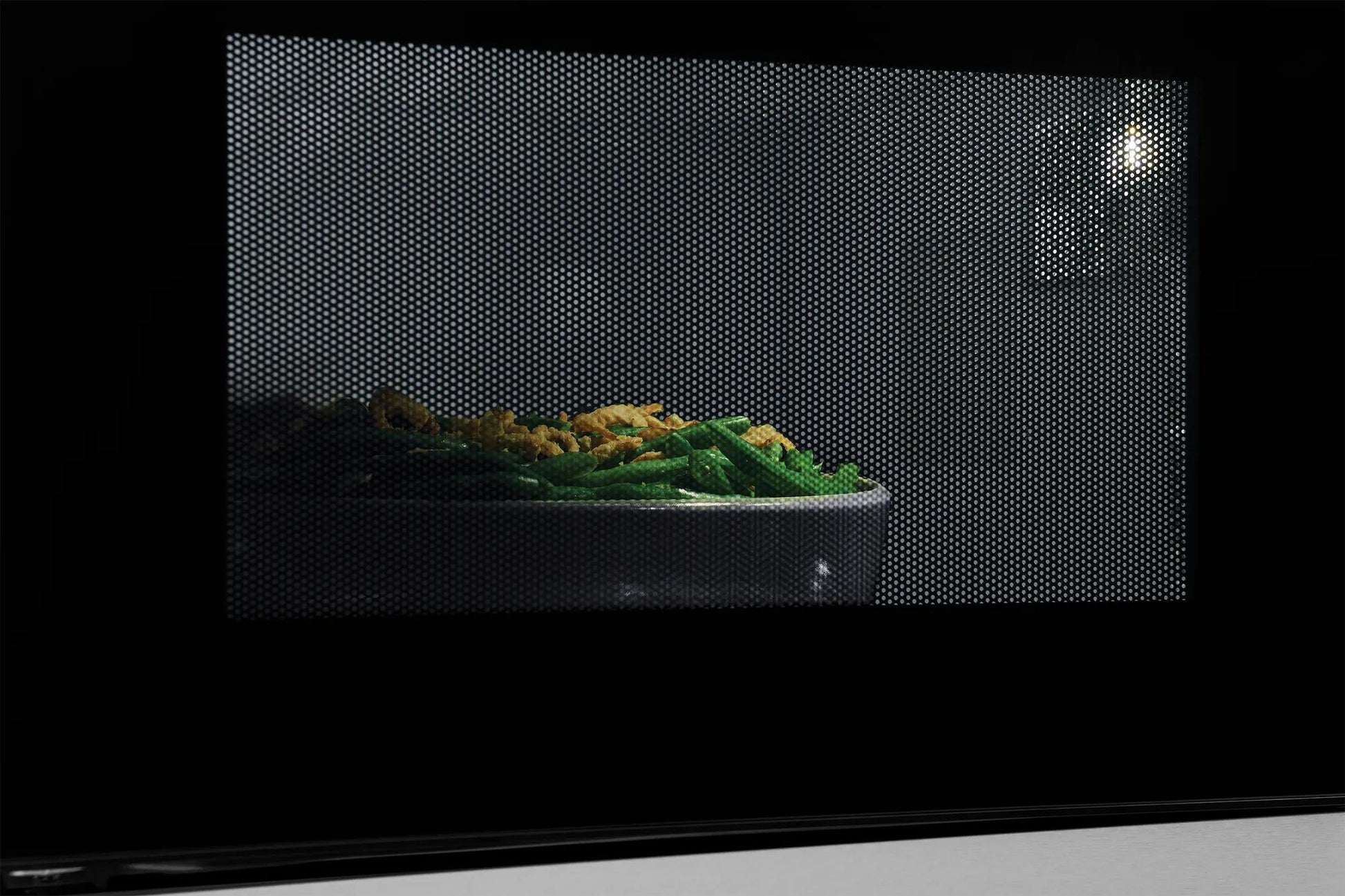 Close-up view of green beans and corn heating inside a built-in microwave from kitchen appliances collection