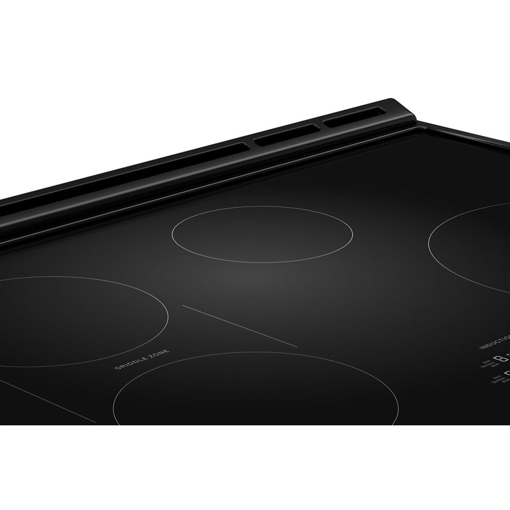 black smooth glass induction cooktop with four heating zones in kitchen and appliances collection