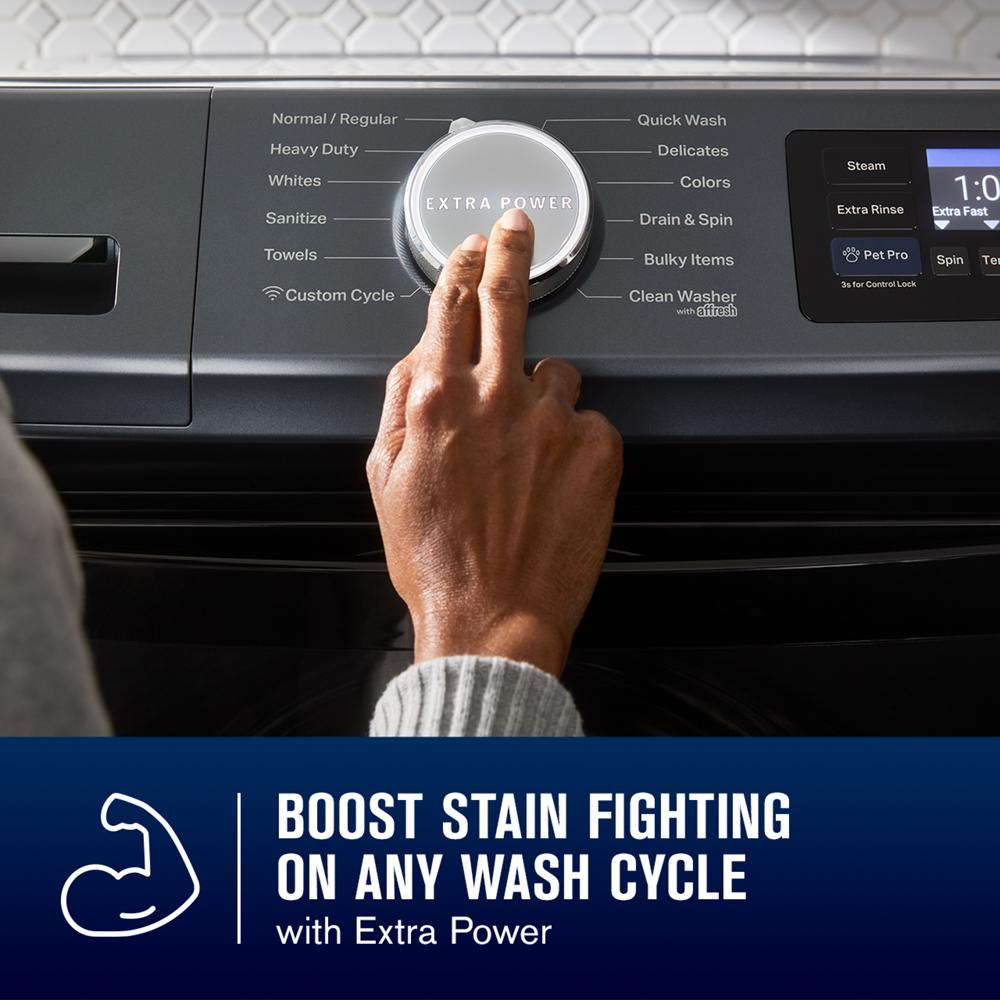 Hand adjusting cycle selector knob on dark gray front load washer with digital controls in appliance setting