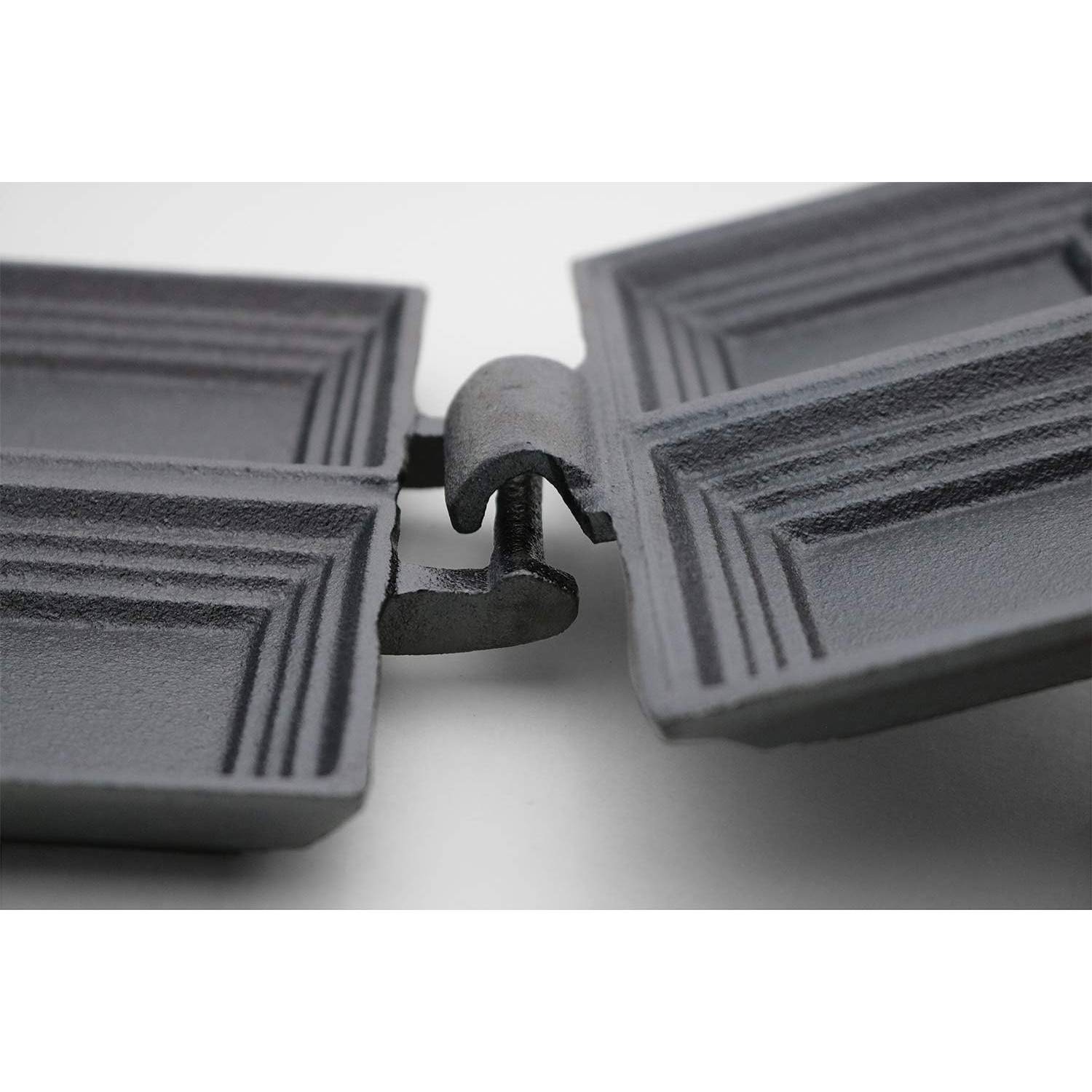 Close-up of hinge mechanism on black cast iron double sandwich cooker for cooking over campfires and outdoor use