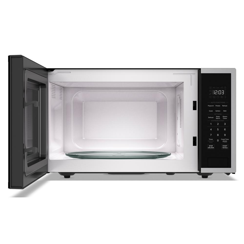 Open stainless steel countertop microwave with digital control panel showing preset cooking options in KitchenAid Appliances collection