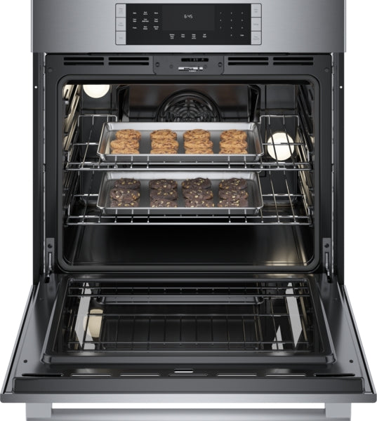 Open 30-inch stainless steel single wall oven with two racks baking chocolate and vanilla cookies in kitchen appliances collection