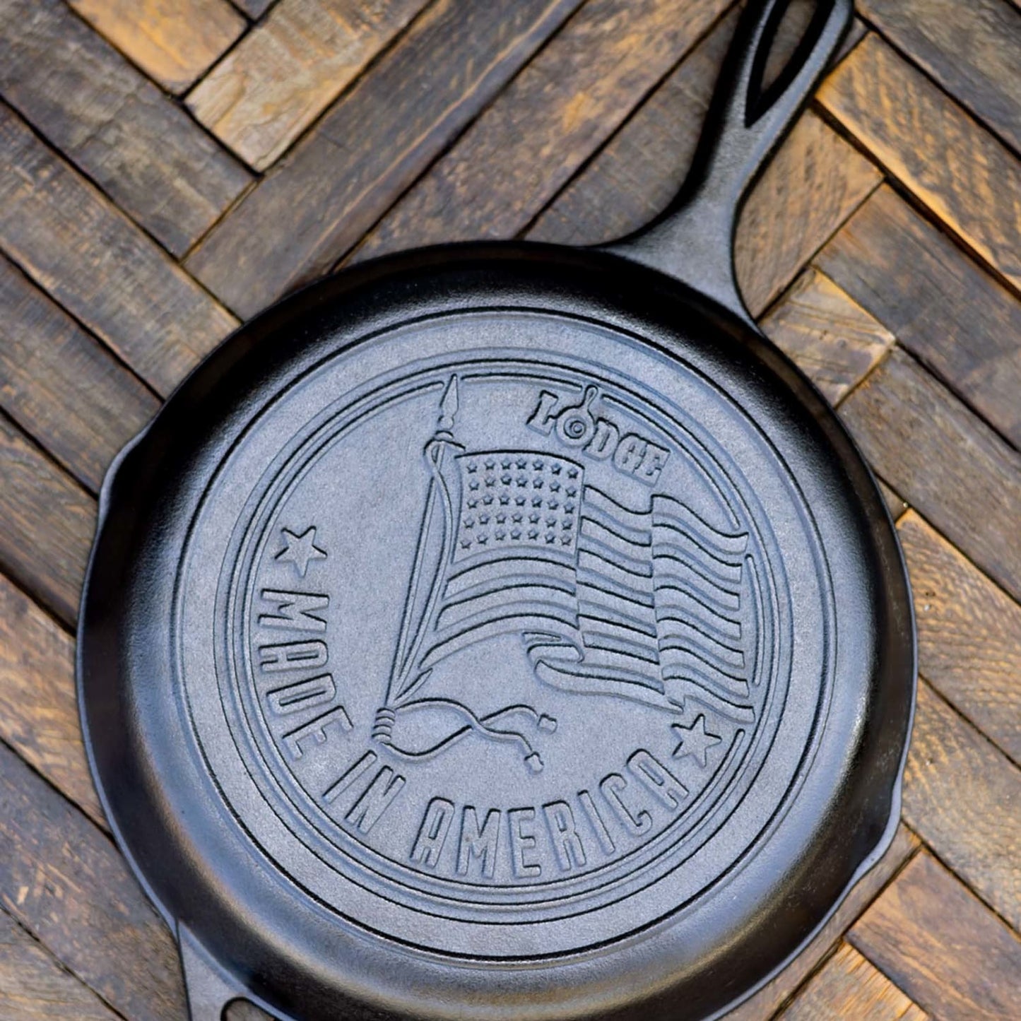 Bottom view of seasoned cast iron skillet with embossed American flag and Made in America text on wooden surface