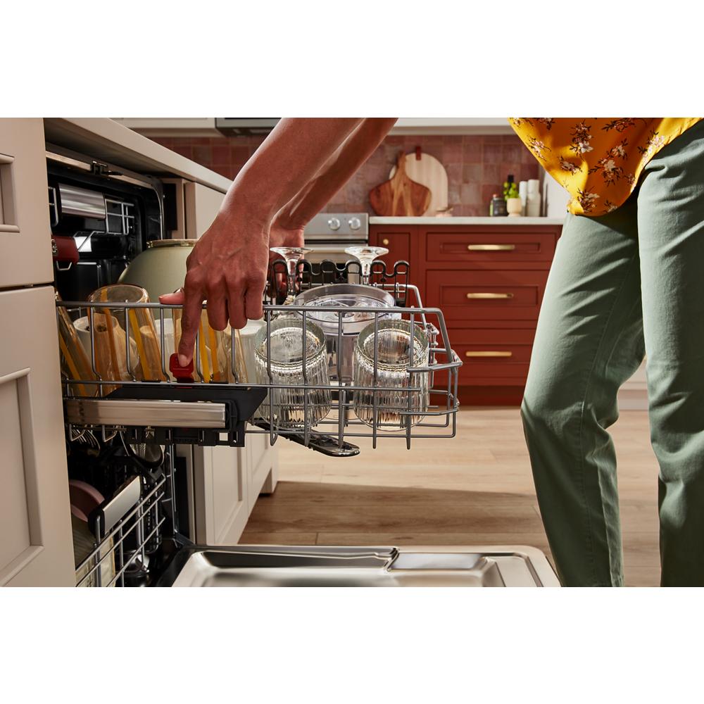 Person loading clear glasses and mugs into an open panel-ready dishwasher in Kitchen & Kitchenware category