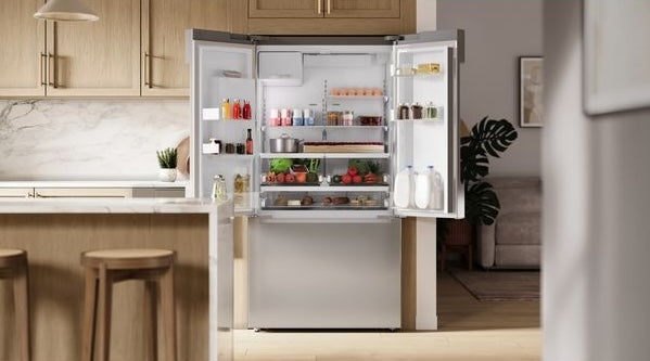 Open French door bottom mount refrigerator in stainless steel with organized interior in modern kitchen setting