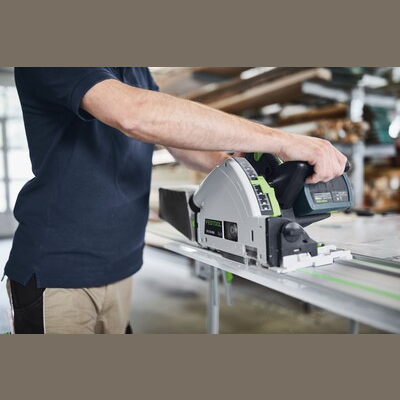 Person using Festool cordless track saw on guide rail to cut wood in workshop for home improvement power tools
