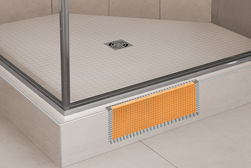 Orange waterproofing membrane applied to the base of a tiled shower curb for home improvement installation