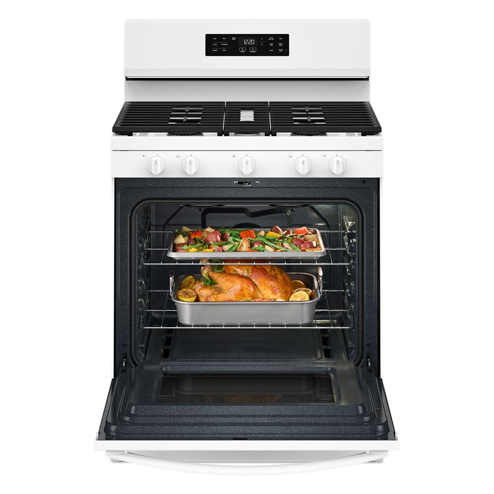 White 30-inch gas range with open oven door showing roasted chicken and vegetables inside from kitchen appliance collection