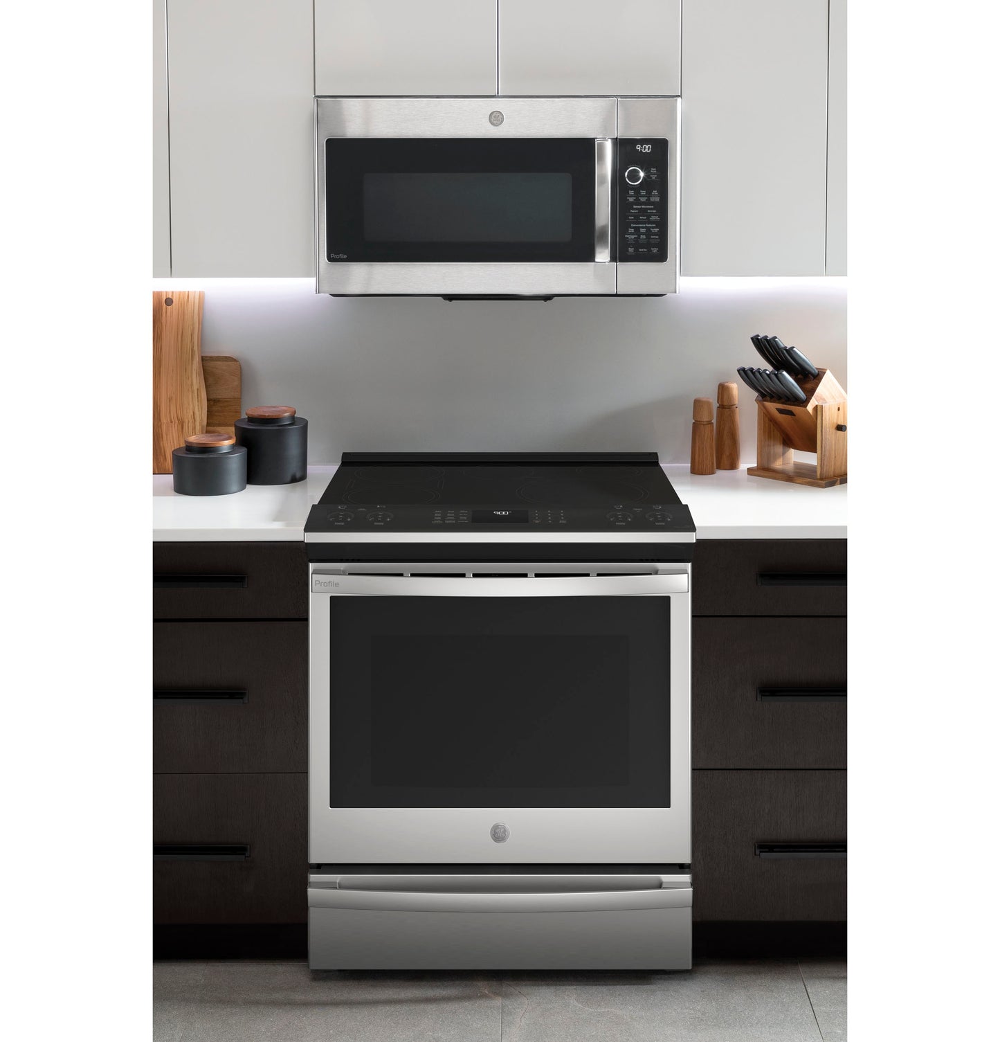 Modern kitchen setup featuring a fingerprint resistant stainless steel induction and convection range with built-in microwave above