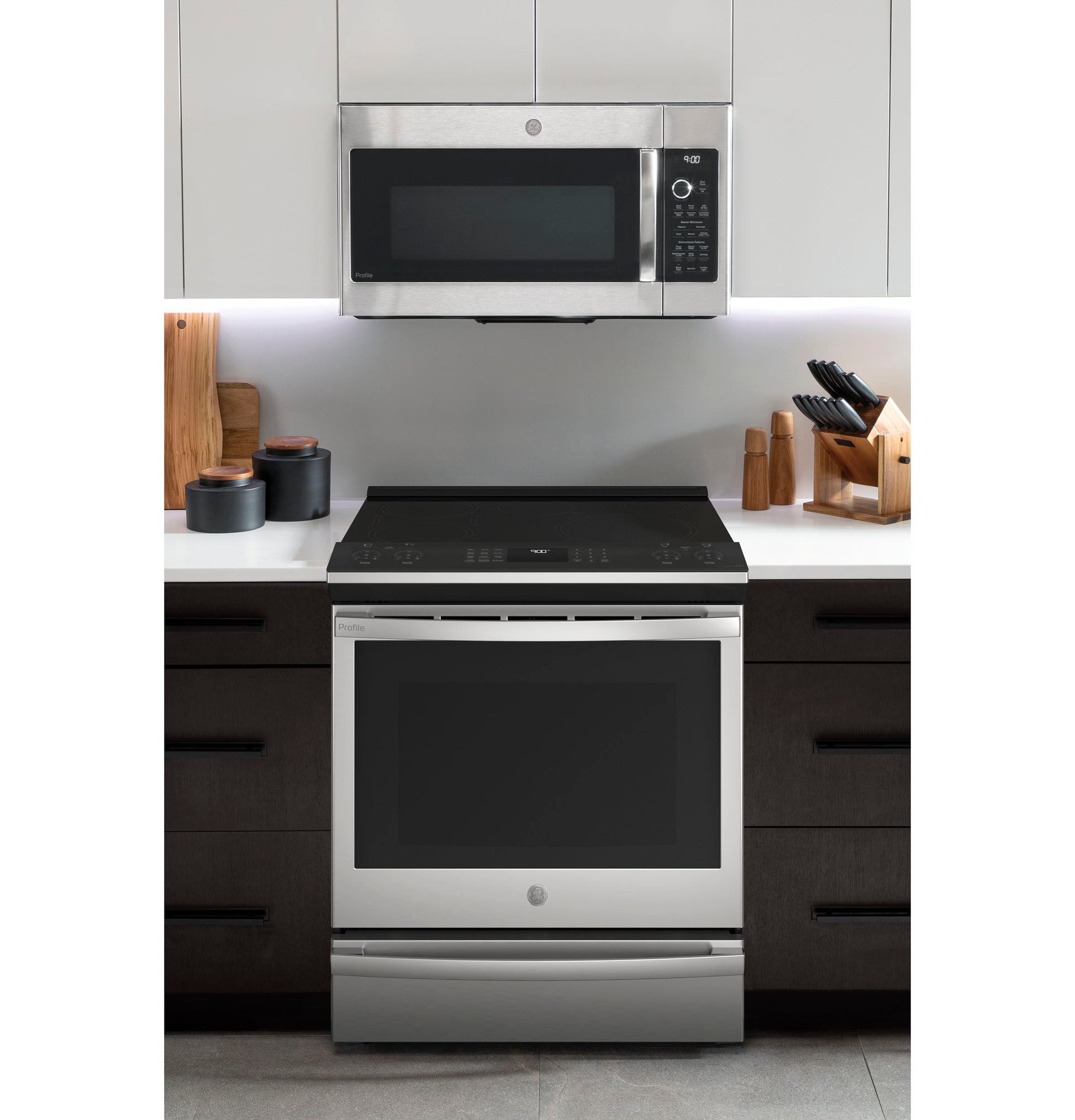 Modern kitchen setup featuring a fingerprint resistant stainless steel induction and convection range with built-in microwave above
