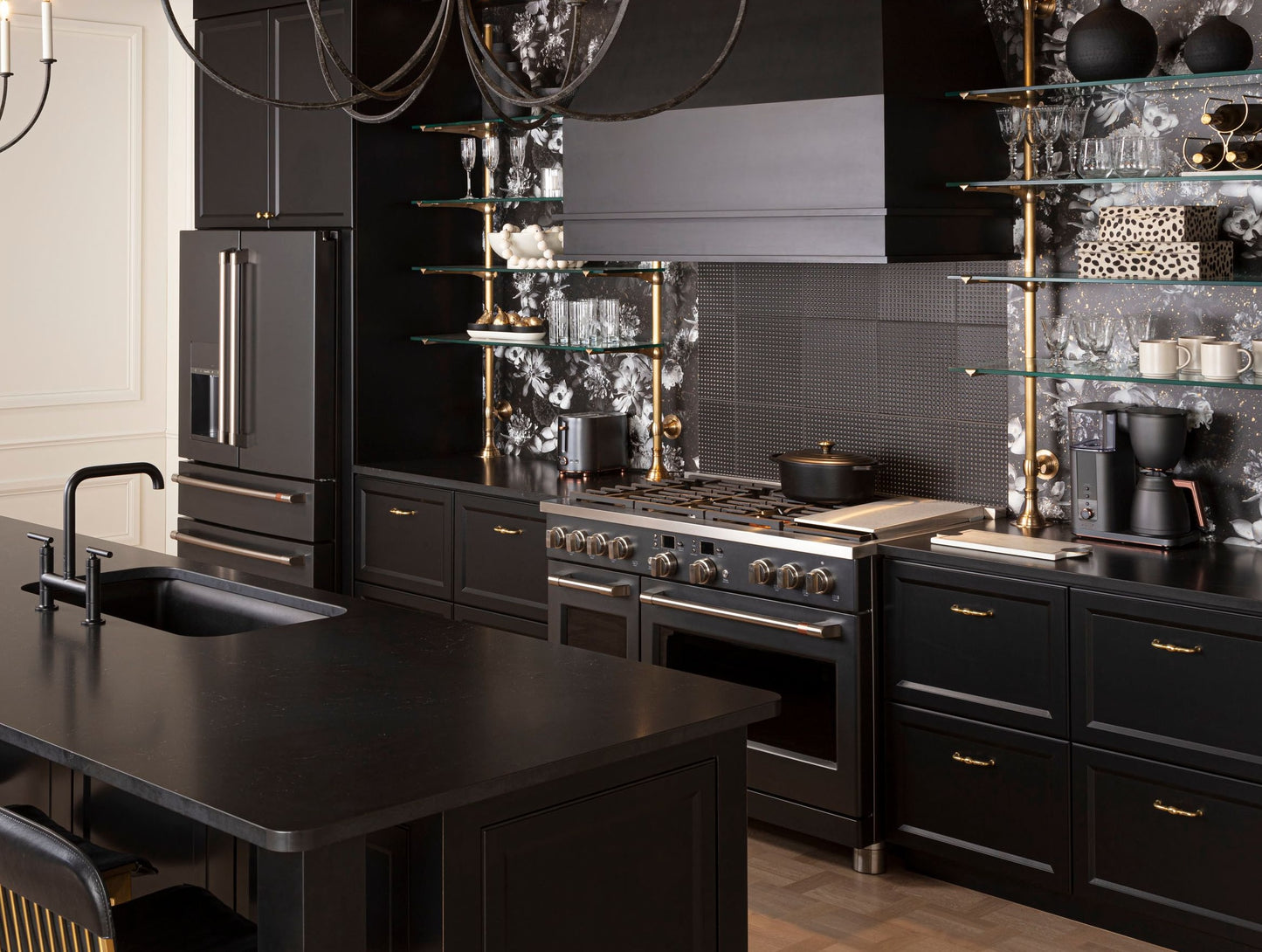 Modern kitchen with black cabinetry, stainless steel appliances, black countertop island, and open glass shelving display