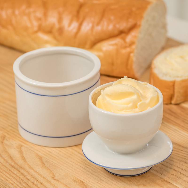 Cream stoneware butter container with blue line accents, ideal for kitchenware and under $50 kitchen accessories collections
