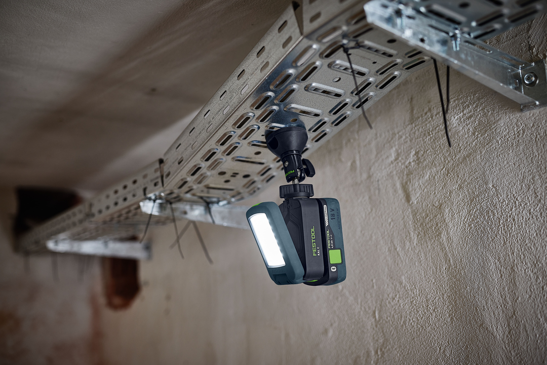 Compact Festool cordless task light with bright LED panel illuminating metal cable tray for home improvement tools