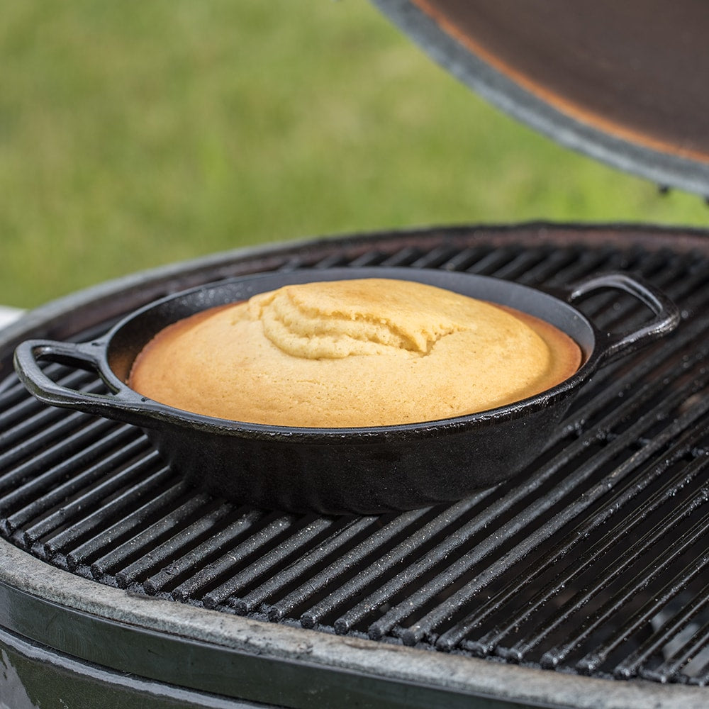 Round cast iron pan baking golden cornbread on outdoor grill for versatile kitchenware under $50 collection