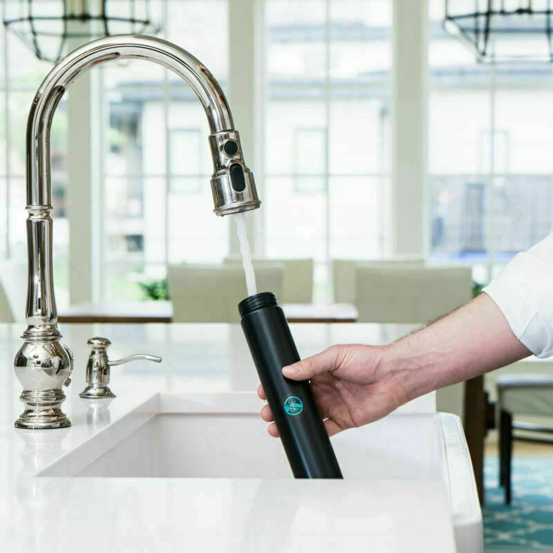 Person filling black cylindrical insect barrier tube from kitchen faucet for lawn and garden pest control under $50 collection