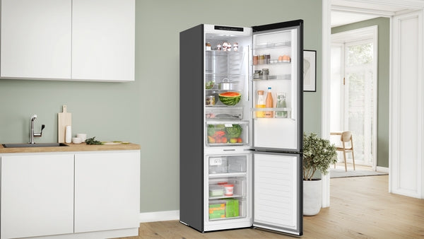 Open black fridge-freezer with bottom freezer compartment showcasing organized fresh produce in modern kitchen setting