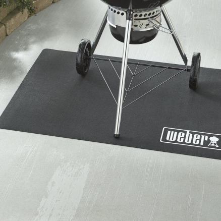 Durable black floor mat for grill area protection with Weber logo, suited for outdoor living and grilling setups.