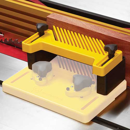 Vertical featherboard with risers clamping a wooden plank on a table saw for improved safety and precision