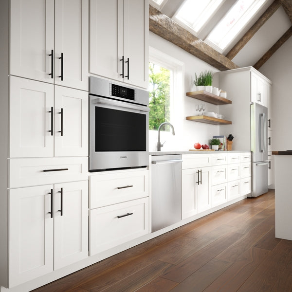 Built-in stainless steel single wall oven integrated into white cabinetry with black hardware in modern kitchen setting