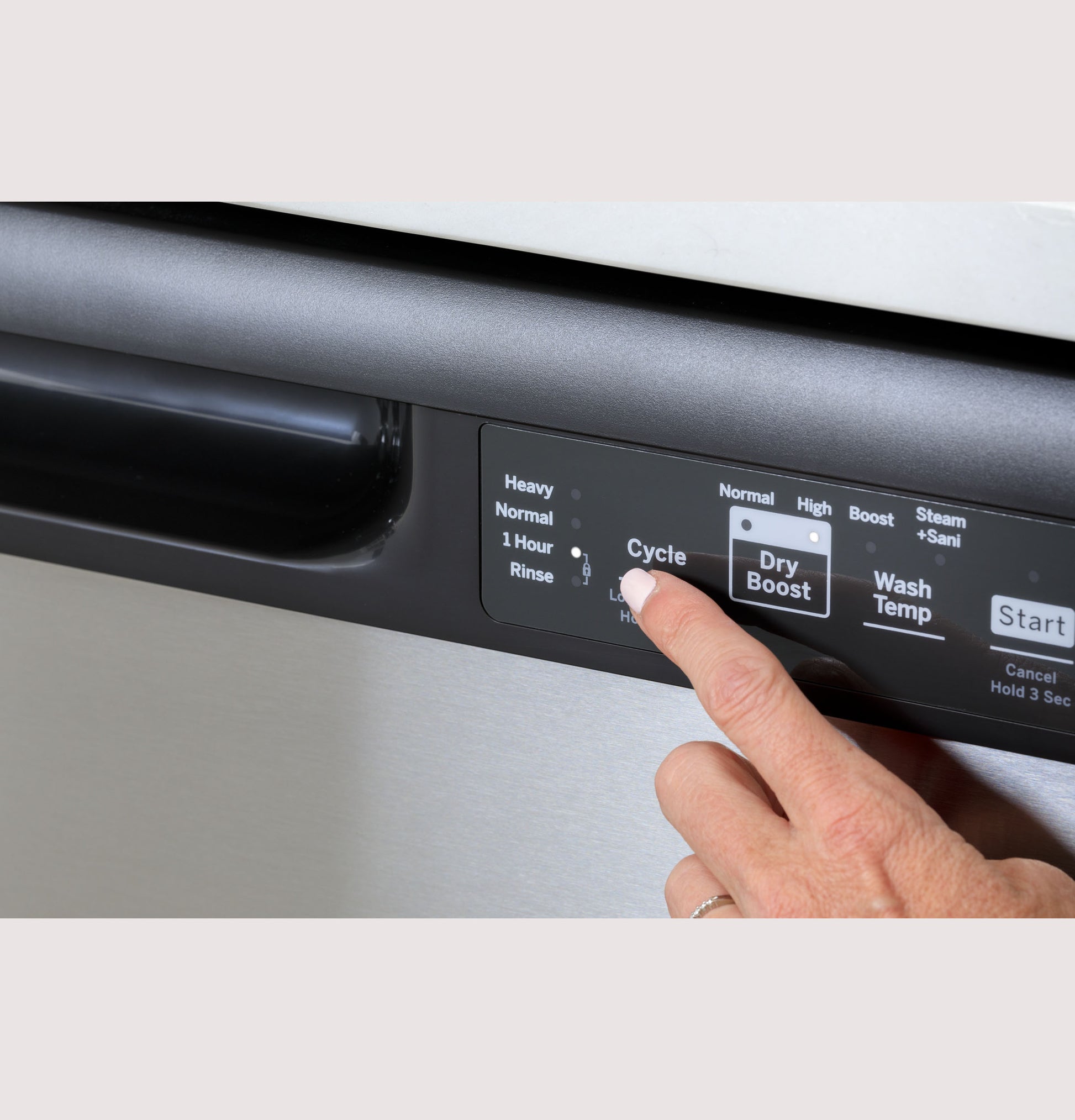 Person selecting cycle options on control panel of stainless steel dishwasher from kitchen appliances collection
