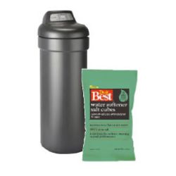 Tall dark gray water softener tank standing next to a green package of water softener salt cubes with branding on the front.
