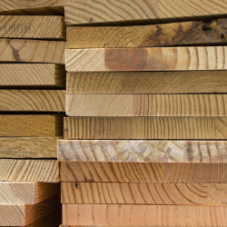 Stack of various wooden lumber pieces with visible grain patterns and natural wood tones, used in construction and home improvement projects.