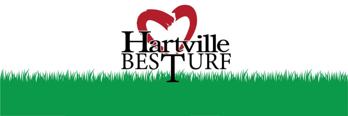 Logo for Hartville Best Turf featuring stylized red heart shapes above the black text, set against a grassy green border at the bottom.