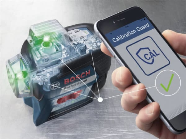 Hand holding smartphone displaying a Calibration Guard confirmation next to a Bosch professional laser leveling tool on a metallic surface.